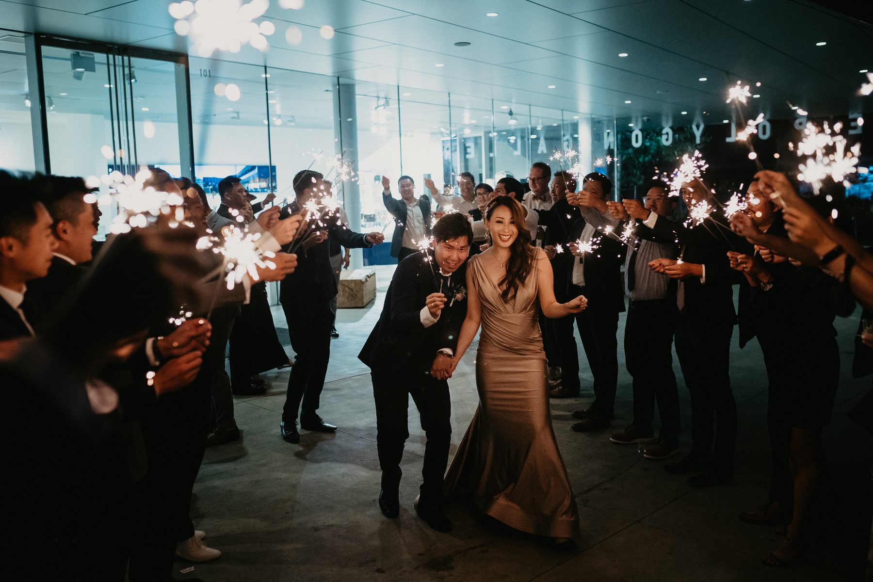Guests hold sparklers overhead as the party moves through the room late in the night