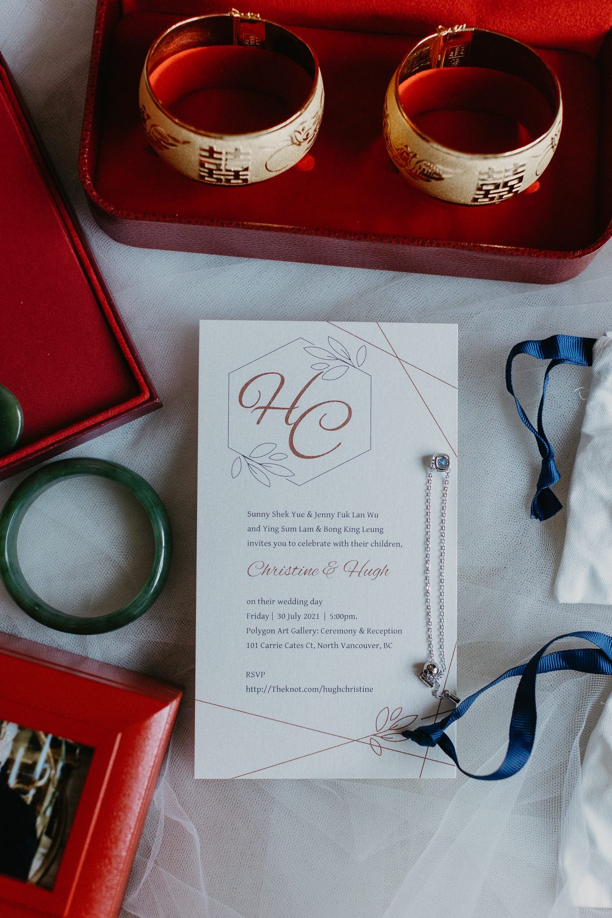 Wedding invitation laid out beside gold and jade bangles and red lacquer boxes before the tea ceremony