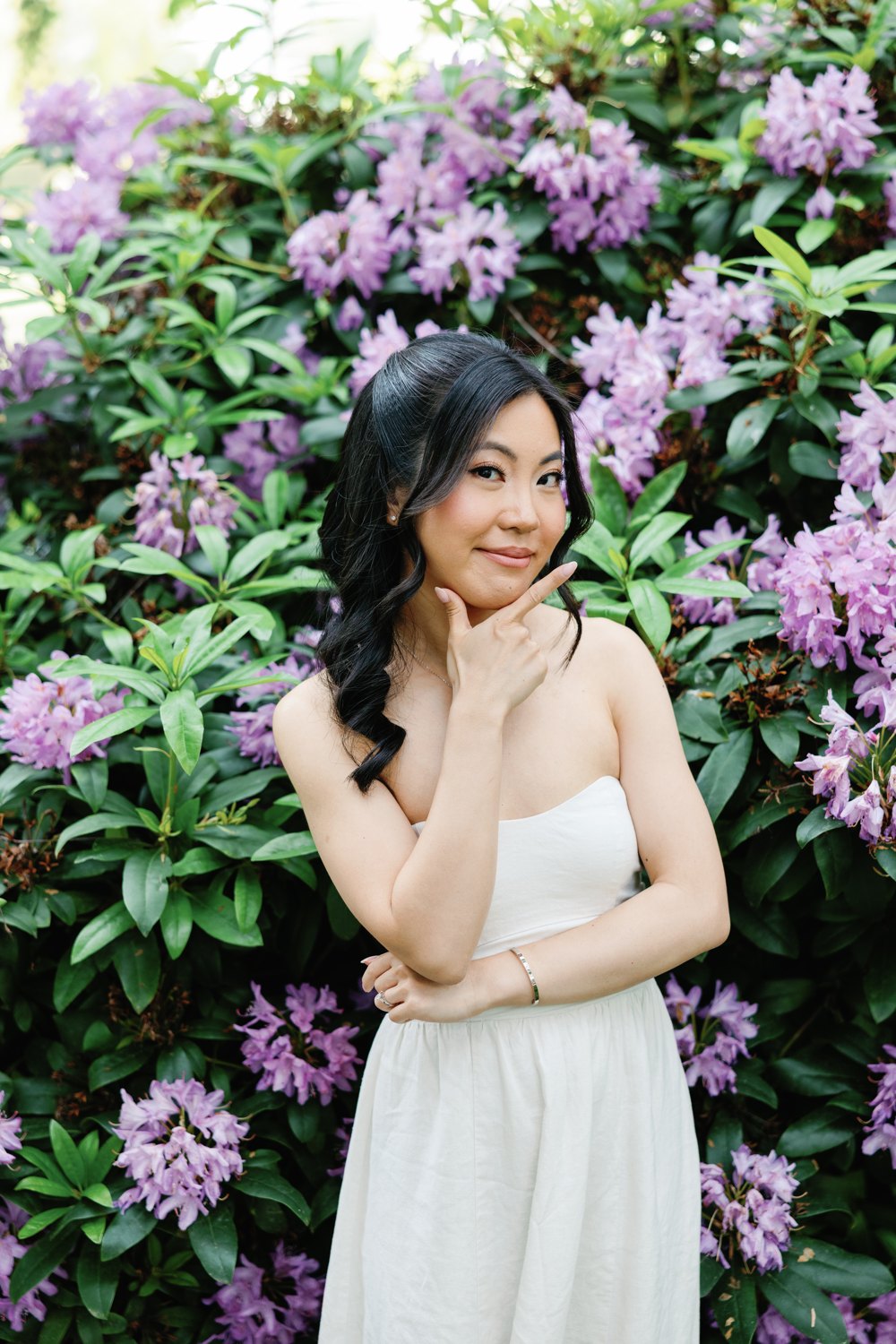 Eunice in a white gown beside lilacs in full bloom