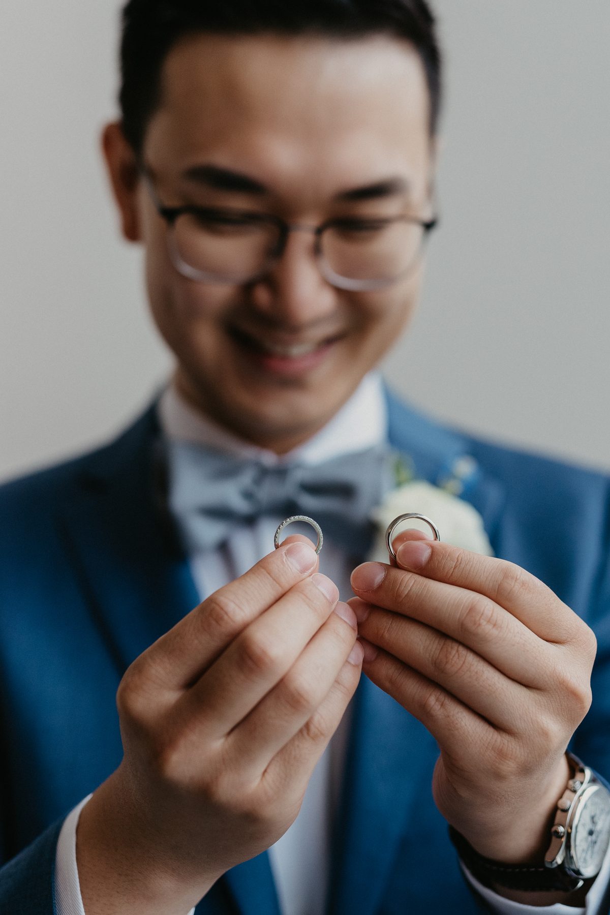 Groom in a blue suit reading a handwritten letter, smiling at the page