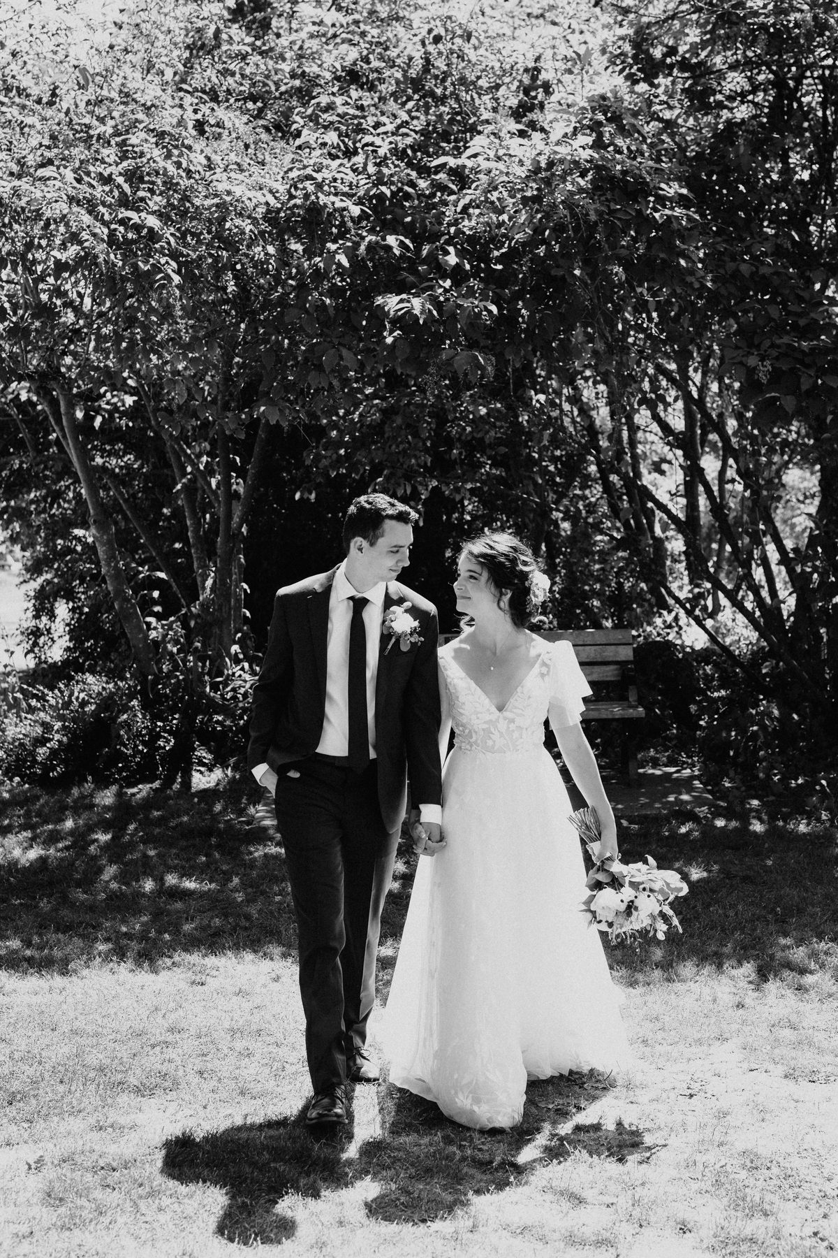 Bride and groom seeing each other for the first time under a canopy of trees, photographed in black and white