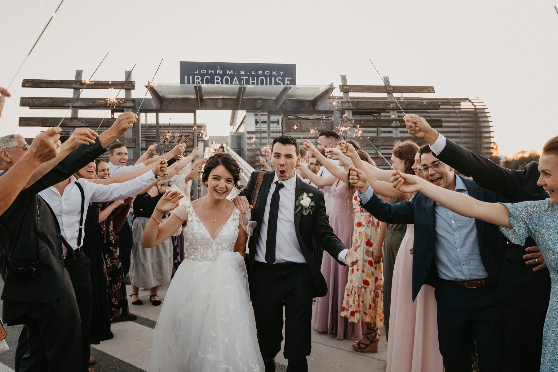 Guests raising their arms into a tunnel as the newlyweds run through it at the end of the night