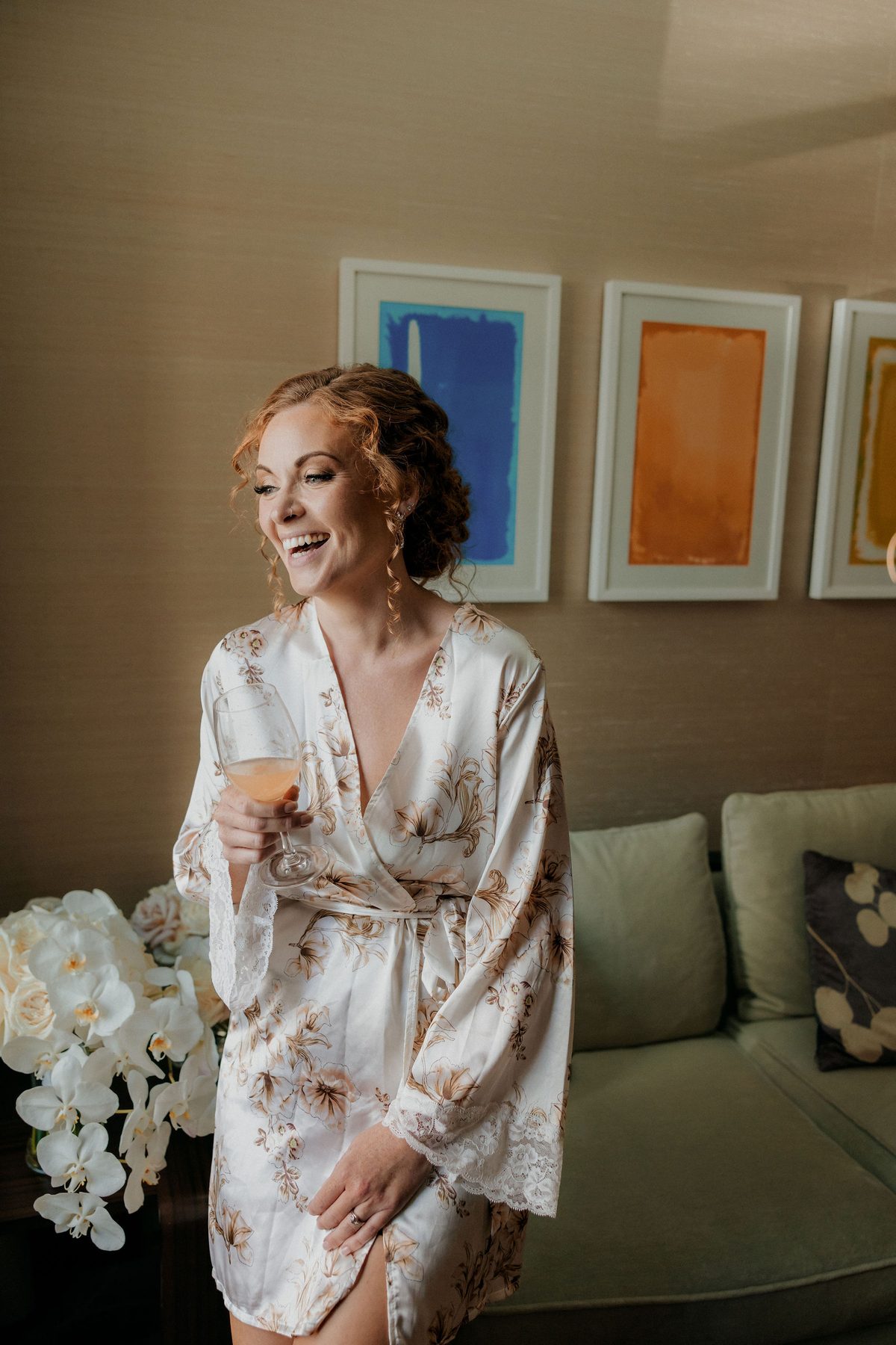 Bride in a silk robe by a window on a grey winter morning