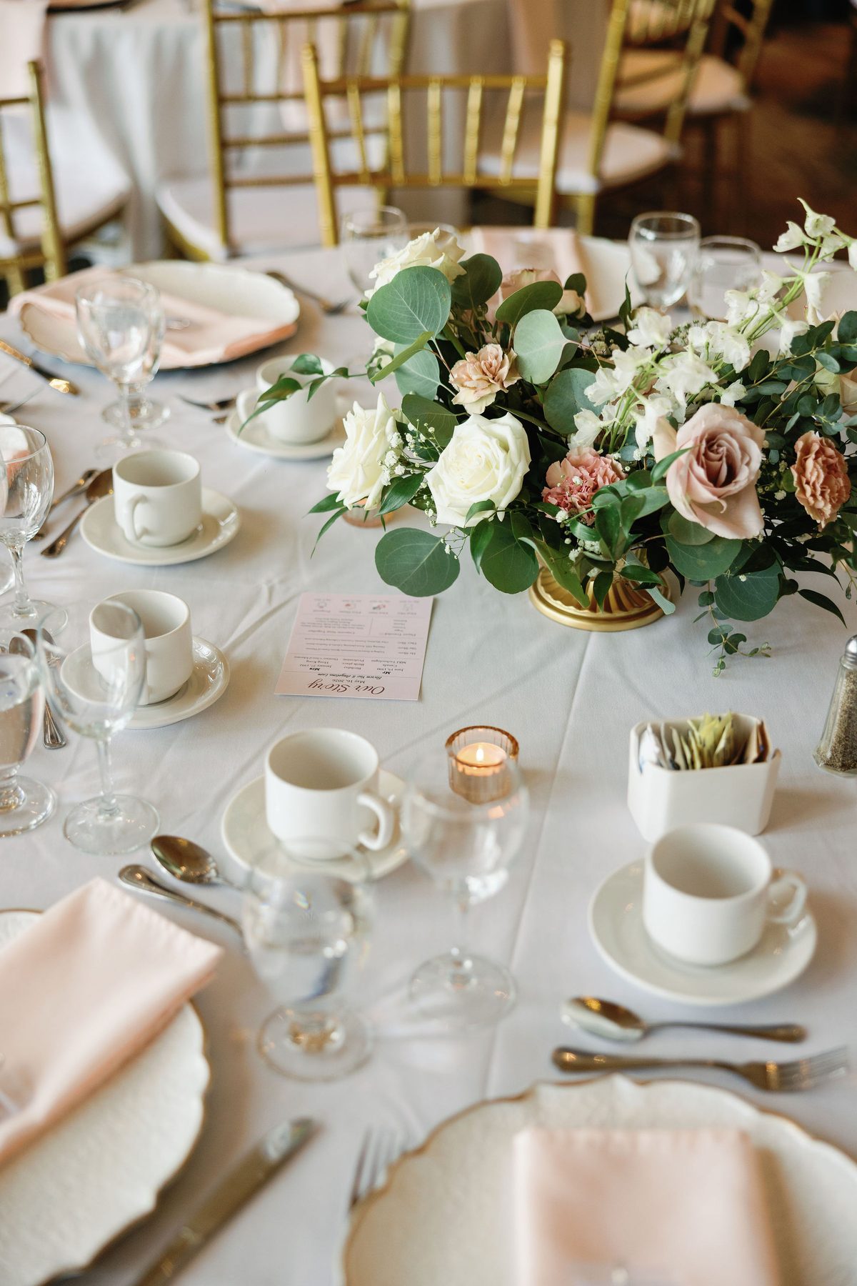 Intimate wedding tablescape with blush roses, gold cutlery and candlelight